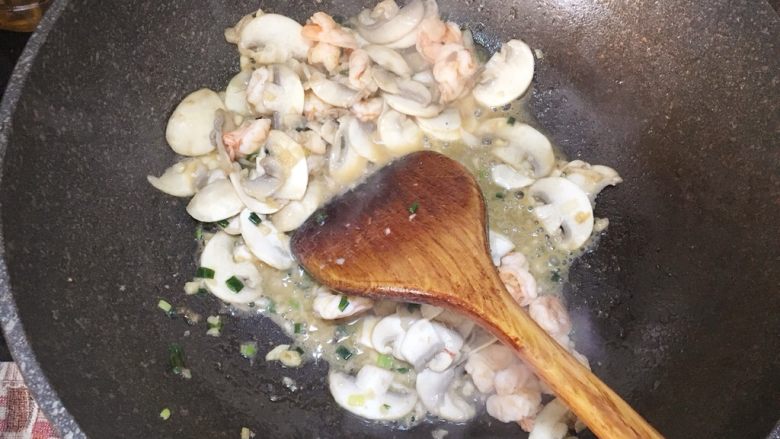 鲜虾蘑菇炒面,把虾仁也一起倒进去翻炒均匀，倒出碗中备用