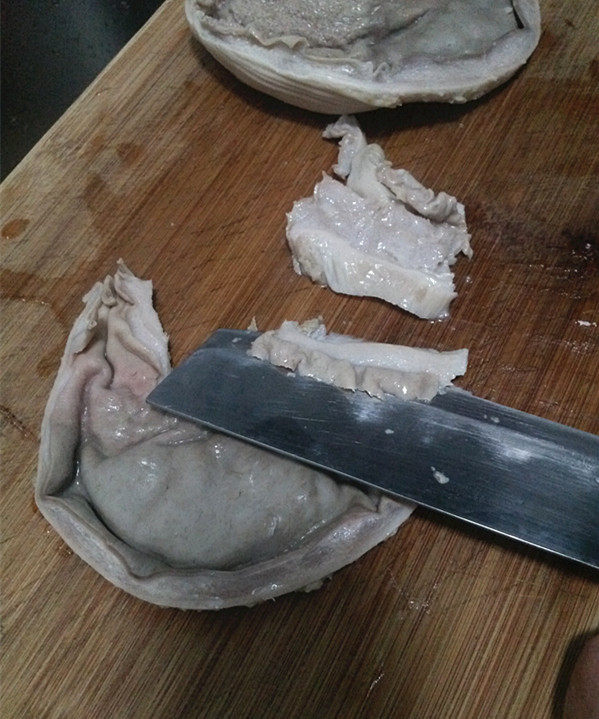 青椒炒肚片,然后顺着弧形状的猪肚，用刀从中间一剖为二，再将刀贴着猪肚斜切大片
