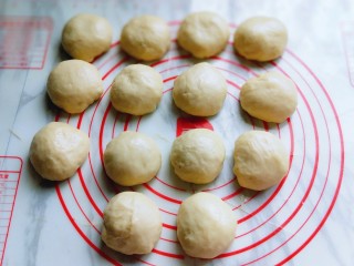 #我的厨房必杀技#布里欧修吐司,发酵好的面团从面包机取出，平均分成14等份，盖上保鲜膜松弛10分钟。