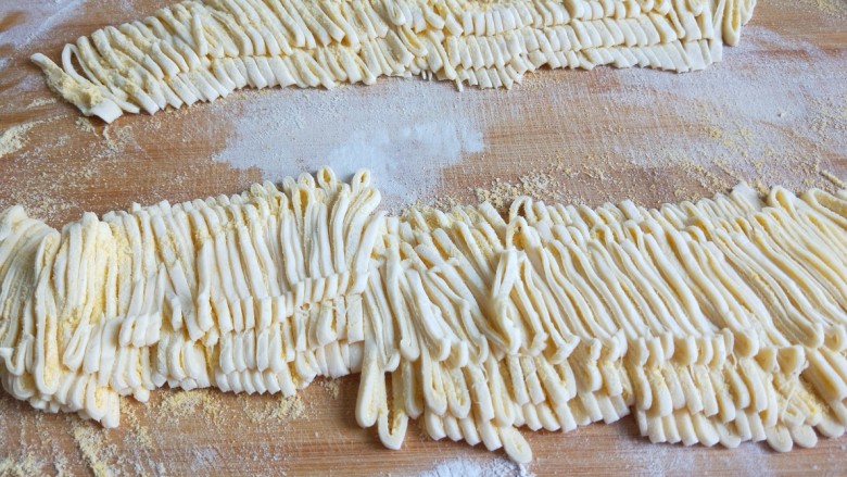 新文美食  双锅豆角焖面,擀成面皮，在撒上玉米粉折叠好切成丝。