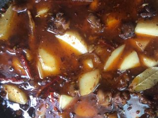 家常川菜土豆烧鸡,加入淹没鸡肉和土豆的清水，盖好锅盖焖煮。中间记得要翻炒，以免粘锅。