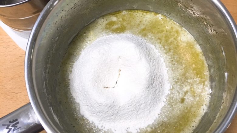 8寸鱼松戚风蛋糕,备用的蛋黄盆，用打蛋器低速搅拌均匀后，过筛低筋粉。