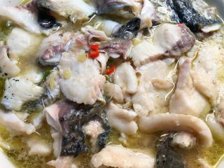 青花椒鱼,把煮好的鱼片连汤一起倒入装鱼头的大碗里