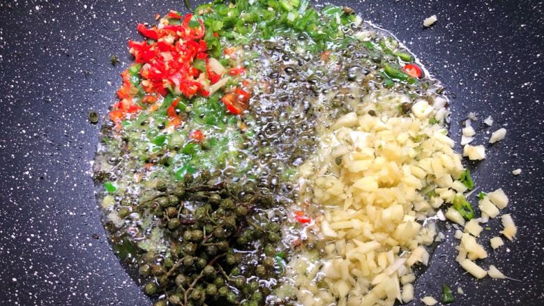 青花椒鱼,把剁碎的青辣椒、小米辣、生姜、蒜头全部放入，再放入20g青花椒一起炒香