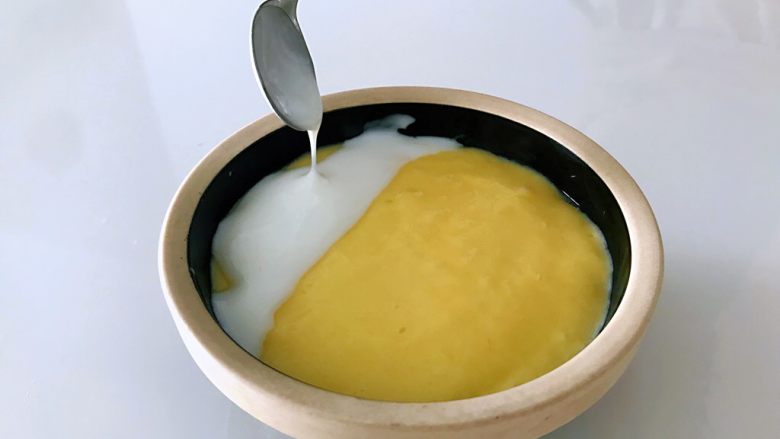 芒果芝香思慕雪,表面三分之一处铺上一层酸奶。