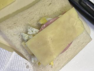 口袋三明治,依次铺在面包上，底部芝士、火腿片、鸡蛋对半叠、火腿片、芝士片