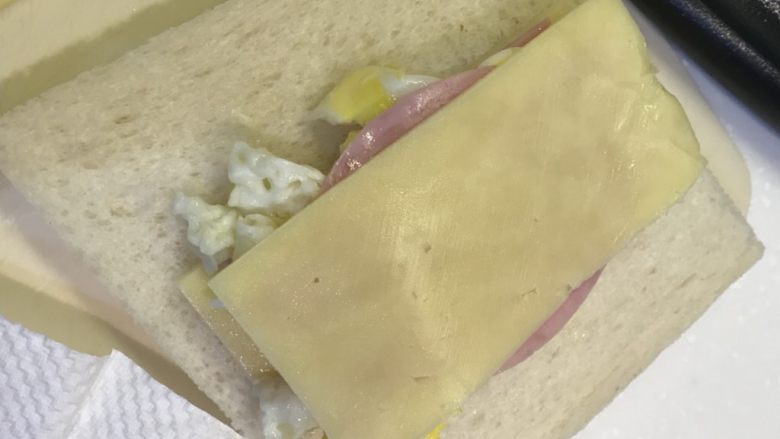 口袋三明治,依次铺在面包上，底部芝士、火腿片、鸡蛋对半叠、火腿片、芝士片
