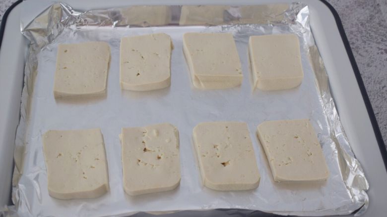 麻辣烤豆腐,将豆腐切成大上厚薄均匀的长方块，放在铺好锡纸的烤盘上