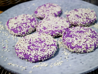 紫薯饼,随后滚上一层芝麻,两面都要滚上芝麻，再用擀面杖把饼压扁定型。
