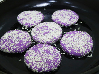 紫薯饼,起锅,待油温升高,放入山药紫薯饼，小火煎制(如果是不粘锅也可不用加油）