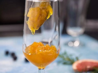 橙子苏打水,取出冷藏好的橙子果肉泥，倒入杯子三分之一的位置。