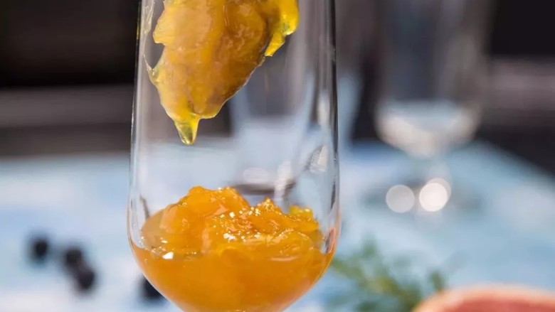 橙子苏打水,取出冷藏好的橙子果肉泥，倒入杯子三分之一的位置。