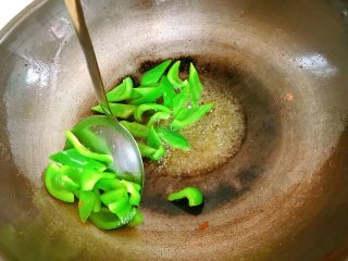 青椒炒肉片,锅中热油，把青椒炒至断生沥干油暂捞出。