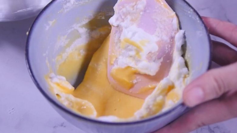 舒芙蕾小松饼
,取一勺蛋白霜到蛋黄糊中，翻拌均匀