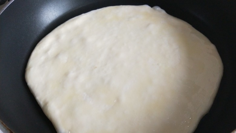新文美食  千层饼,把擀好的饼放锅中，面上刷一层油。