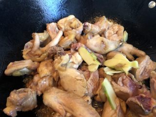 红烧小公鸡,将水气炒干，鸡块边缘略有糖色，即可下入姜片同炒。