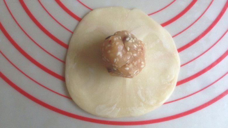 蔓越莓豆沙酥饼,擀成中间厚四周薄的圆形，放入馅料收口。