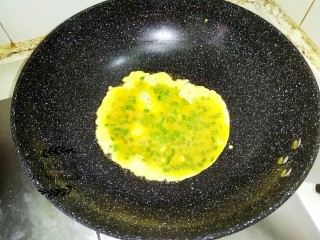 双色蛋卷,锅里下油，稍微加热后把蛋黄液倒进锅里，蛋黄液倒入锅里前先搅拌均匀，免得里面的盐和鸡粉没有融化而沉底。小伙把蛋黄煎成饼。