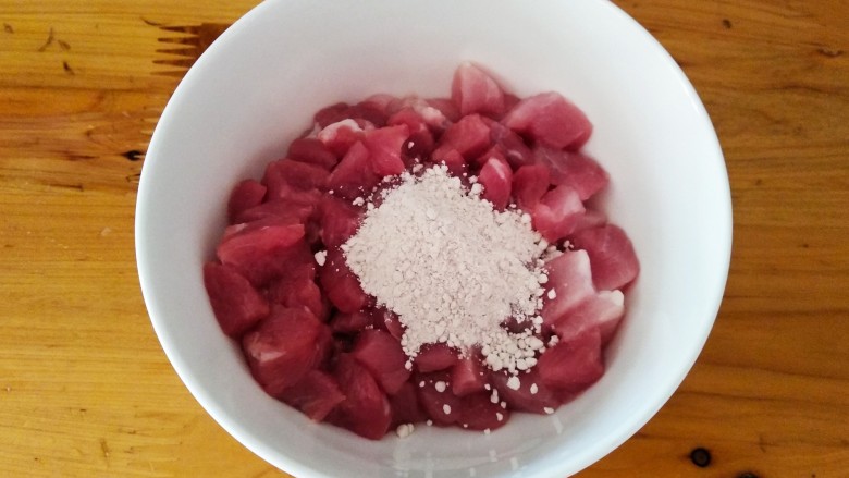 芹菜胡萝卜炒肉丁,肉丁放入碗中，然后放一勺淀粉。
