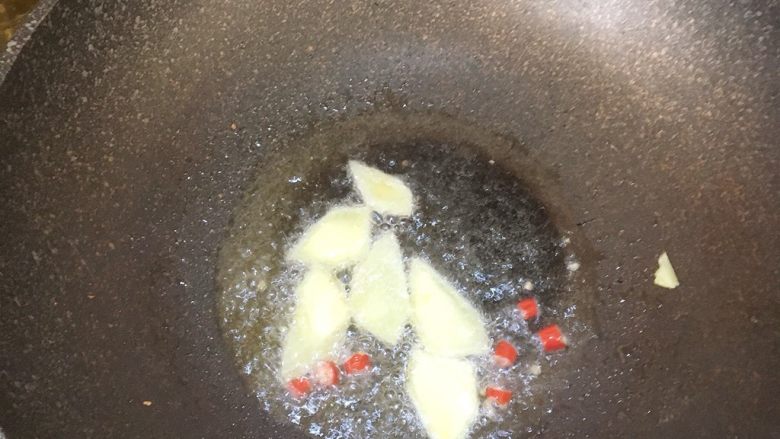 高压锅版黄焖鸡,锅中烧油放入生姜片和辣椒末爆香