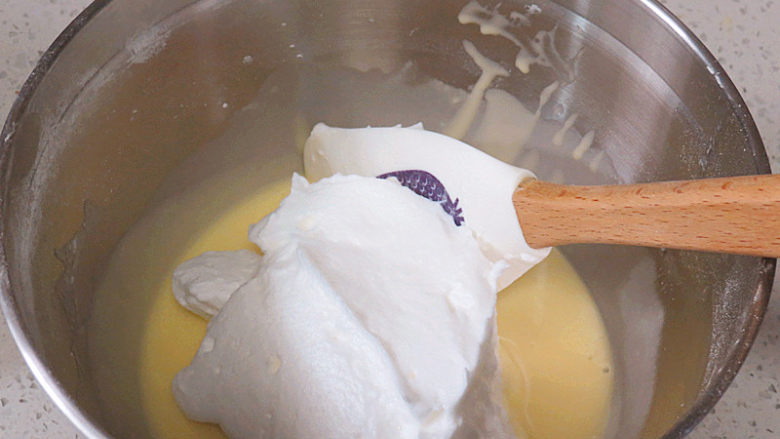 七夕情人节之【心相印乳酪夹心蛋糕卷】,开始混合~先预热烤箱，上下管180度。取1/3蛋白霜放入蛋黄糊中，用刮刀快速翻拌均匀