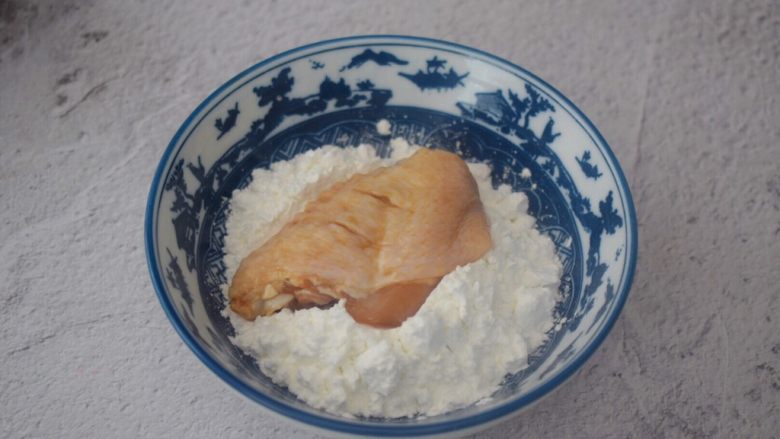 脆皮鸡翅,从冰箱取出鸡翅，先把鸡翅放入玉米淀粉中沾上一层薄薄的淀粉