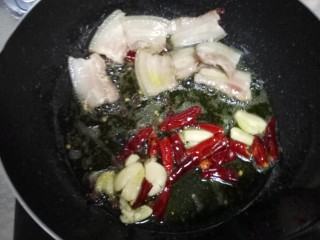 干锅菜花,把肉拨到一边，下蒜和干辣椒，炒香