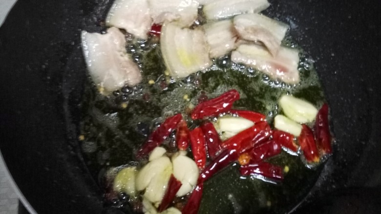 干锅菜花,把肉拨到一边，下蒜和干辣椒，炒香