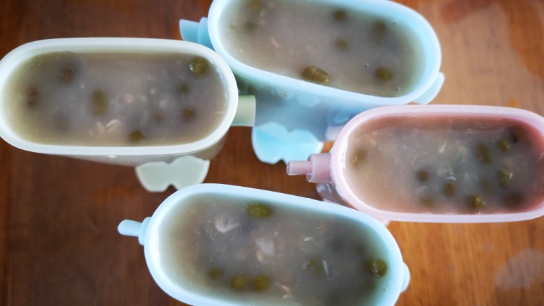 牛奶绿豆冰棒,将晾冷的绿豆汤舀入模具中