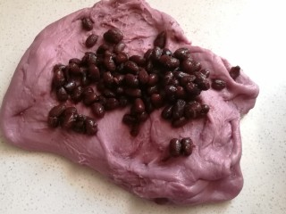 淡奶油紫薯蜜豆吐司,揉好的面团取出来，加入蜜红豆用手揉均匀。