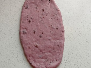 淡奶油紫薯蜜豆吐司,取一份醒发好的面团，用擀面杖擀成椭圆形。