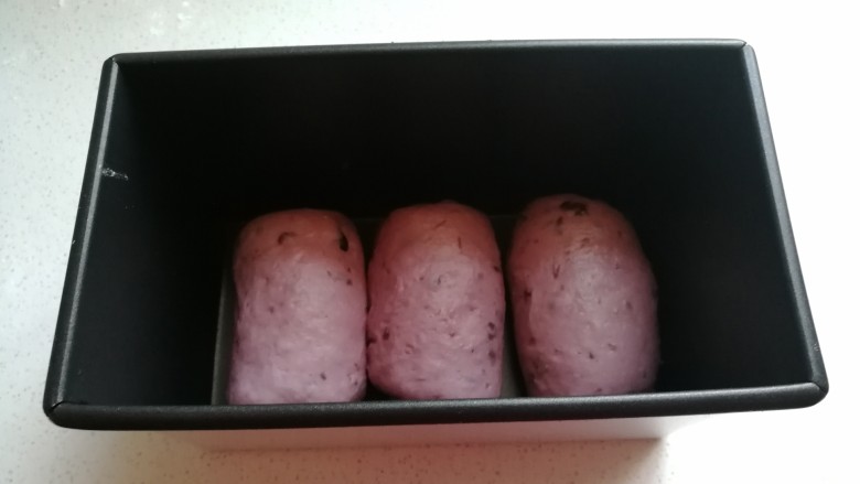 淡奶油紫薯蜜豆吐司,再依次做好剩下的两个面团，把它们摆入450吐司盒中进行发酵。