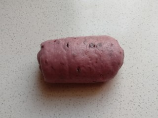 淡奶油紫薯蜜豆吐司,把擀好的长舌状面片再次从底部向上卷起来，卷好后摆放入吐司盒中。