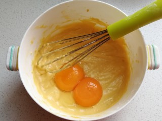 蔓越莓南瓜戚风蛋糕,蛋清蛋黄分离，加入两颗蛋黄，用手抽同上方法继续搅打均匀。