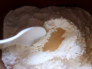 汉堡胚面包,除黄油外的食材全部加入面包桶，盐和糖对角放，鸡蛋1个，奶粉，再加入高筋面粉，最后再面粉的顶端挖个洞，把酵母粉加入洞洞里，再用周边的面粉盖起来。
