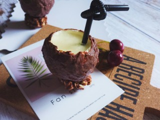 法式甜点–夏威夷风情椰子,将冷冻至硬的球形慕斯蛋糕取出，刷上融化的巧克力，沾一点巧克力放上坚果底座。一颗“伪装”的椰子就完成啦~！
