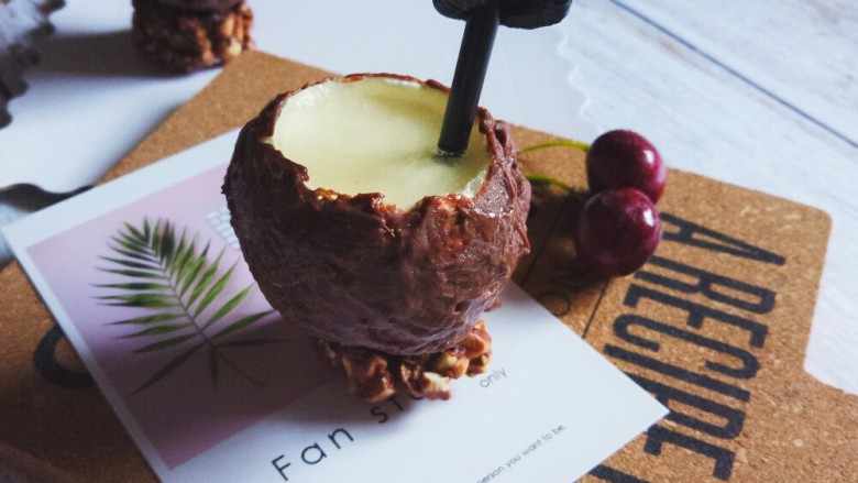 法式甜点–夏威夷风情椰子,将冷冻至硬的球形慕斯蛋糕取出，刷上融化的巧克力，沾一点巧克力放上坚果底座。一颗“伪装”的椰子就完成啦~！