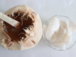 杨枝甘露，自制椰浆版,首先来制作椰浆，椰子取汁后，敲开顶部，用勺子或者比较结实的铁片，取出椰肉。