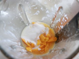 杨枝甘露，自制椰浆版,用刀取出芒果粒，中间的芒果可以留一些，最后装饰用，其他的放入破壁机中，加入150克刚才制作的浓椰浆，加入适量的牛奶。启用果蔬模式，得到了细腻的芒果椰奶。如果芒果不甜的话，这步可以加入适量蜂蜜，或者是白砂糖。