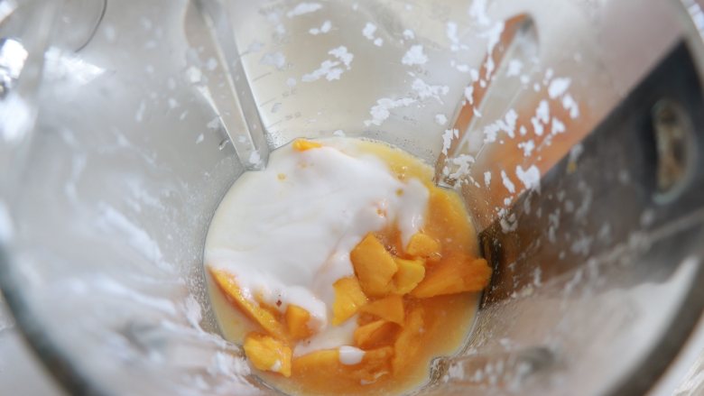杨枝甘露，自制椰浆版,用刀取出芒果粒，中间的芒果可以留一些，最后装饰用，其他的放入破壁机中，加入150克刚才制作的浓椰浆，加入适量的牛奶。启用果蔬模式，得到了细腻的芒果椰奶。如果芒果不甜的话，这步可以加入适量蜂蜜，或者是白砂糖。