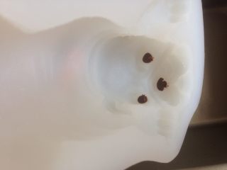 3D沙皮狗慕斯蛋糕,巧克力豆装入裱花袋中，隔温热水融化，挤到眼睛和鼻子的相应部位，看清楚，别挤错地方了哟。我觉得眼睛就挤那么圆圆的一点就可以了，别全部填充眼睛部位，不好看的。放入冰箱冷冻，使眼睛冷冻成型，备用