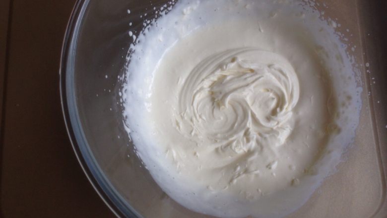 3D沙皮狗慕斯蛋糕,隔冰水或者冰袋，用电动打蛋器打至六分发的状态，不要打到裱花的状态，否则与芒果泥不易混合