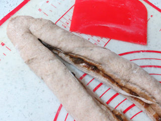 健康美味手撕包【肉桂果干黑麦面包】,将整成圆柱体的面团用刮刀纵向剖切，分成两半将切面朝上，注意面团的一端不要切断