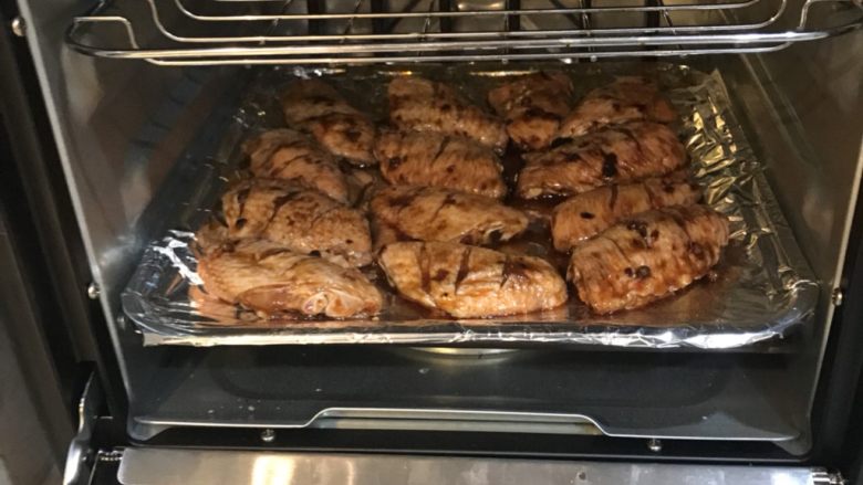秘制烤鸡翅,腌制好的鸡翅放在烤盘上，烤箱200度上下火烤25-30分钟左右，到鸡翅全熟就可以了