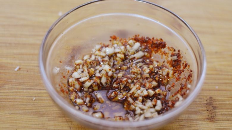 重庆口水鸡,将蒜末连同油，一并倒入装有辣椒粉的碗中，搅拌均匀。