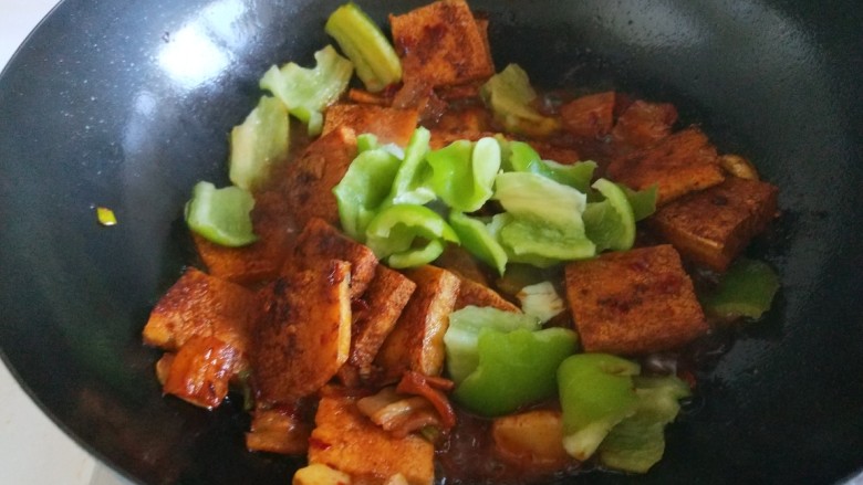 新文美食  红烧冻豆腐,在加入尖椒炒均匀，出锅前放入适量鸡粉炒均匀即可。