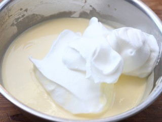 轻芝士蛋糕,打发好的蛋白先将1/3加入步骤7做好的面糊中，用刮刀翻拌均匀，然后倒入剩余的蛋白霜盆中，用刮刀翻拌均匀