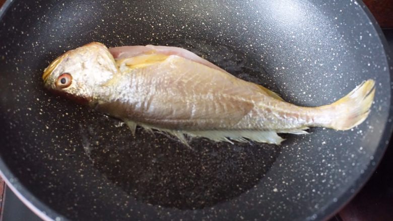 红烧黄花鱼,锅里热油，然后将吹干的鱼放入锅里小火煎香，煎至两面金黄即可