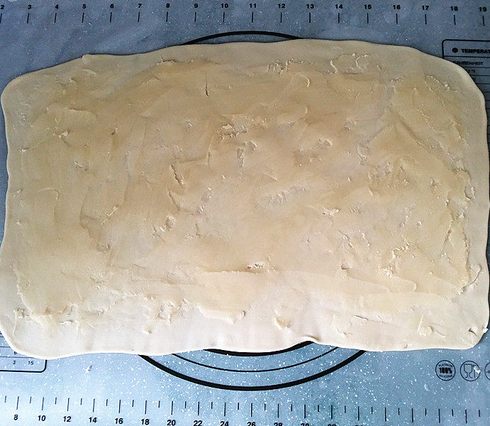 黑芝麻桑葚酥烧饼,将面团用擀面杖擀成大簿片，再均匀抹上一层油酥
