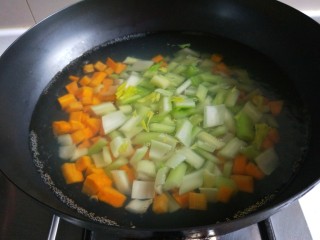 新文美食  凉拌素什锦,烧开水先倒入胡萝卜丁煮两分钟，在倒入西芹。